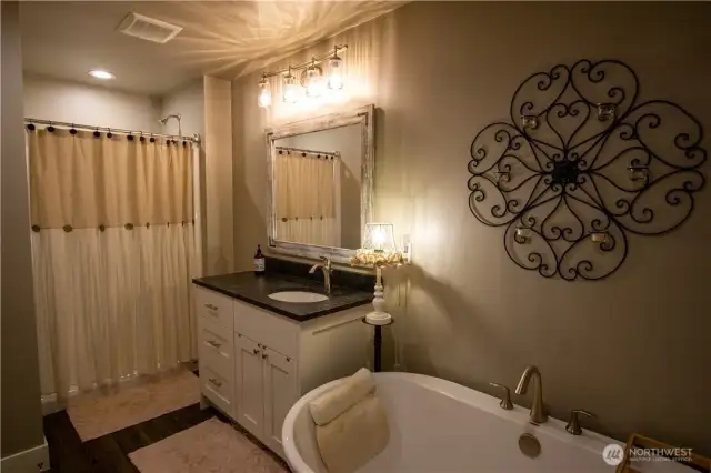 Upstairs guest bathroom with shower and a soaking tub.