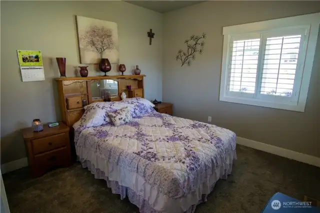 ADU bedroom with custom wooden shutters throughout.