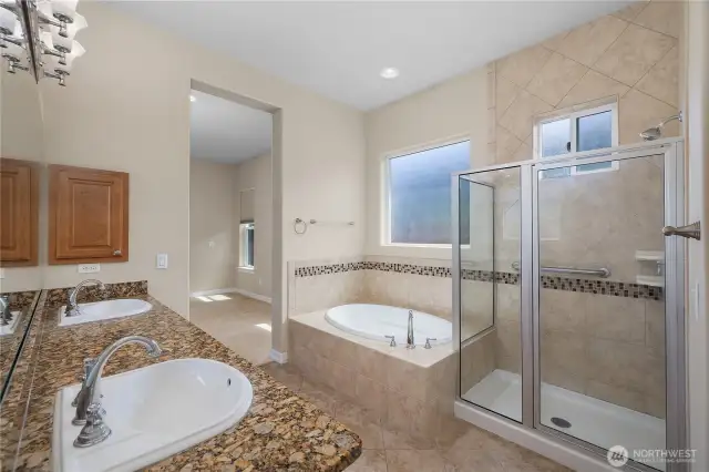 Large Primary bathroom featuring full tile shower, tub, double vanity and grantie countertops.