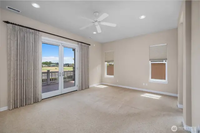 Primary bedroom featuring French doors to covered porch and blackout blinds for comfort.