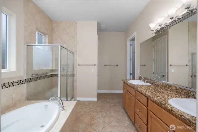 Large Primary bathroom featuring full tile shower, tub, double vanity and grantie countertops.