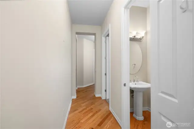 Hallway from Laundry/Garage entry to Primary with 1/2 Bathroom on the Right.