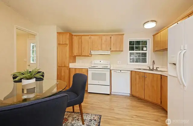 Brand new oven range, plenty of cabinetry and a lovely kitchen sink window that looks out upon cedars & firs. The hot water heater is in a panel located to the right of the doorway that leads to the utility room, and on the left is the door to the backyard.