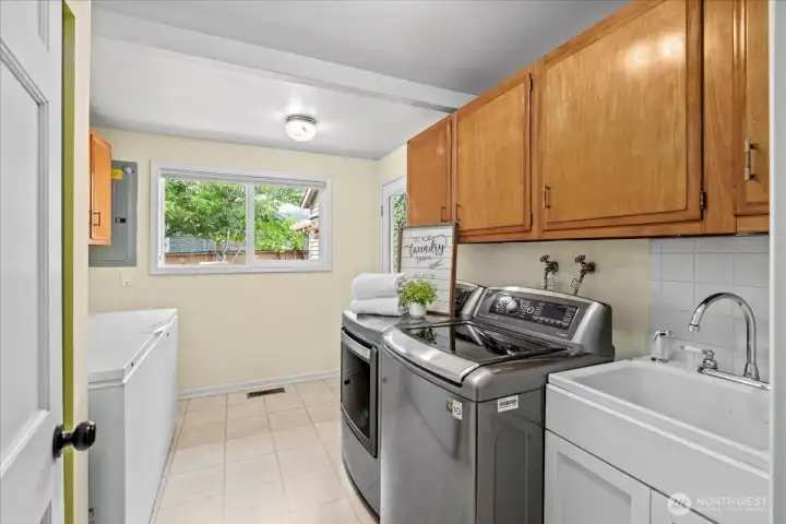The mud room features plenty of storage space, washer/dryer, laundry sink, freezer as well as direct access to the back patio.