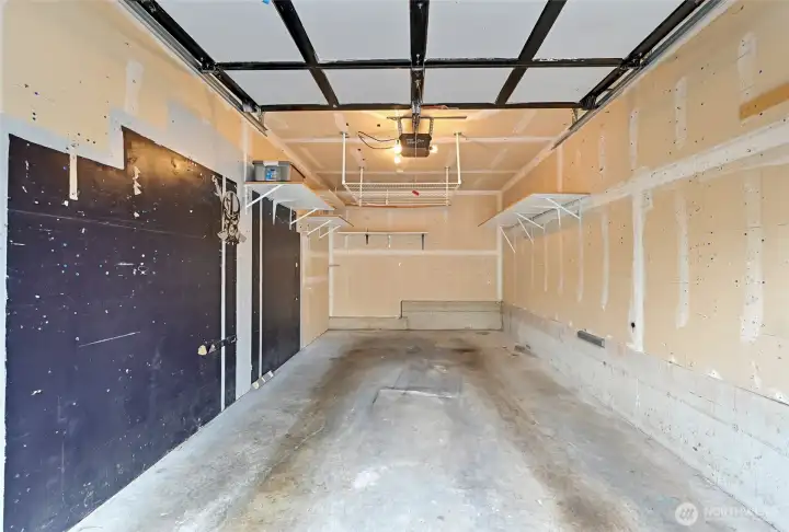 Deep garage with convenient shelving and overhead storage helps you with all of your seasonal storage needs.