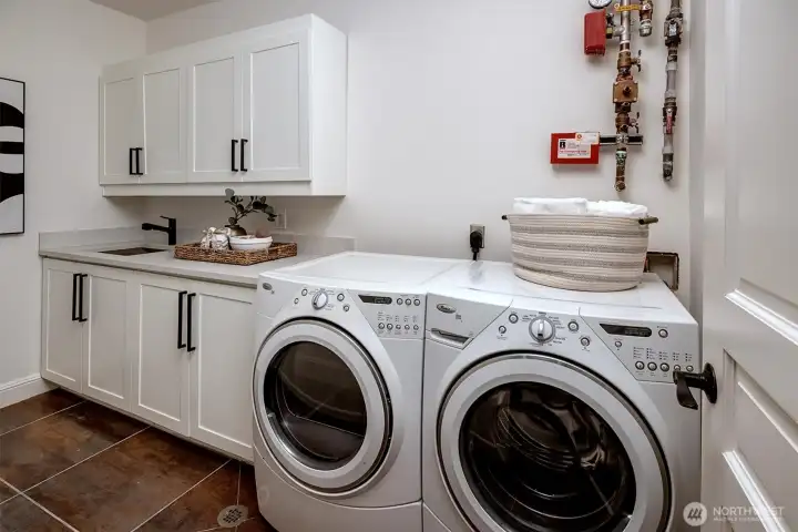 Stylish Laundry Room with brand new quartz counters and matte black hardware!