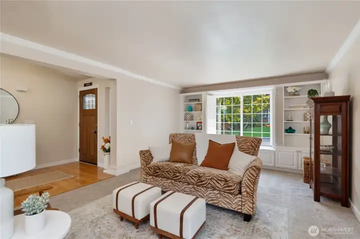 Large formal living area with built in shelving and plantation shutters.