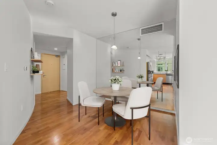 Dining area – Positioned near the entry with floor-to-ceiling mirrors that enhance brightness and space