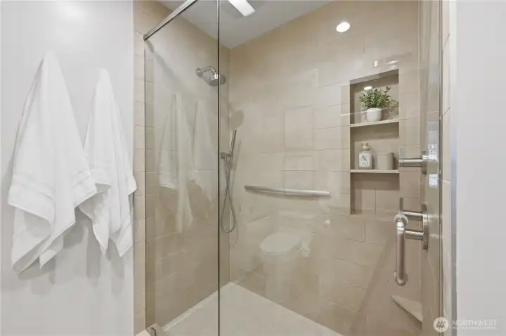 Check out this incredible full glass walk-in shower with built-in shelves for convenience.