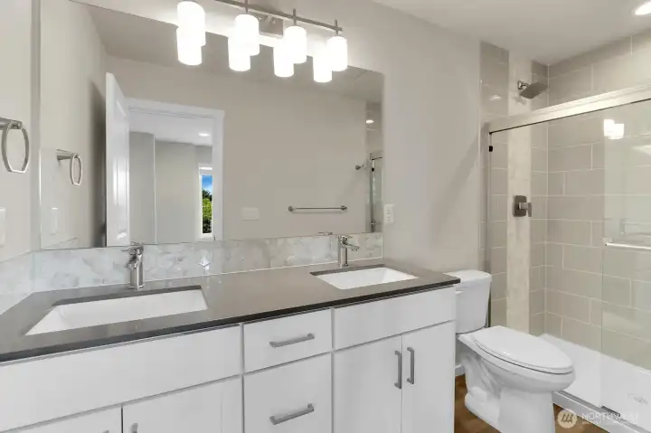 Quartz countertops in all bathrooms. The primary has lovely tile accents.