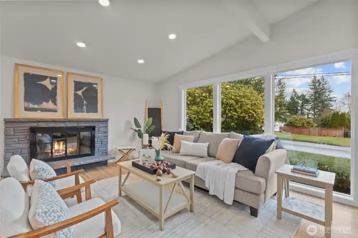 Light-filled living room with vaulted ceilings, recessed lighting, and a stunning brick fireplace.
