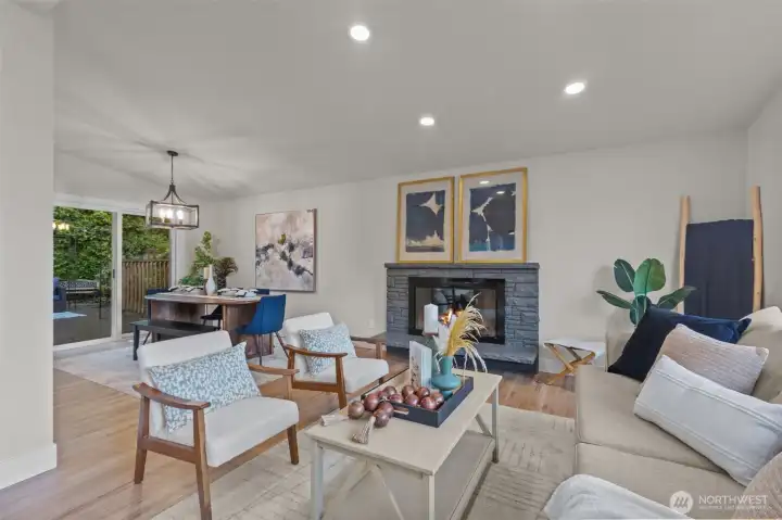 Seamless open-concept design connecting kitchen, dining, and living spaces with beautiful hardwood floors.