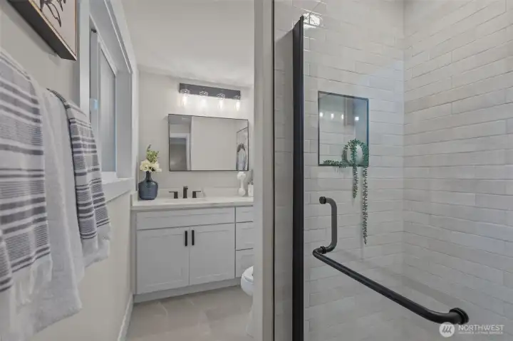 Updated full bath with quartz vanity, subway tile surround, and contemporary finishes.