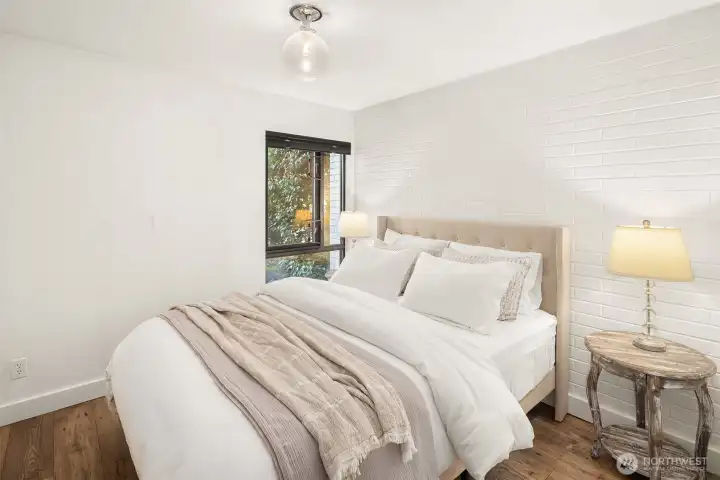 Painted brick wall accents this bedroom. Hunter Douglas Duolite Top-down- bottom up shades with light filtering and blackout options!