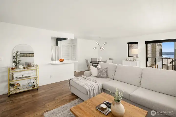 Light and bright! View towards the open kitchen bar, dining area and slider to the deck.