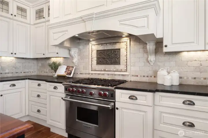 This warm and inviting kitchen boasts a 6-burner Wolf stove/range, back-lit quality cabinets, newer Fisher-Paykel fridge, wine cooler and island seating.