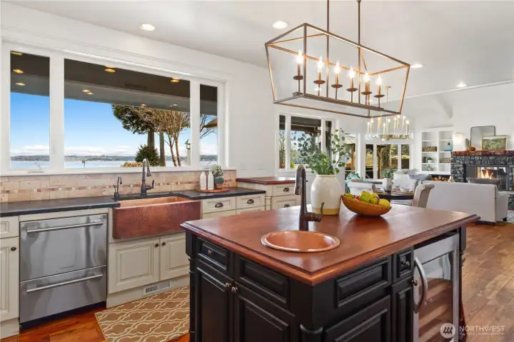 Gorgeous lighting, dual dishwasher, hammered copper sinks, built-in wine refrigerator and incredible water views outside the window are some of the lovely features in this beautiful home.