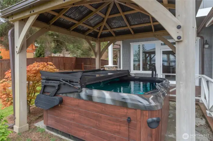 The rarely-used hot tub is just outside of the primary bedroom and under cover.