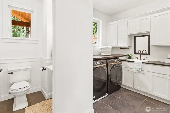 The wonderful utility room has nearly-new washer/dryer, sink, spacious storage cabinets, built-in ironing board and a one-quarter bath.