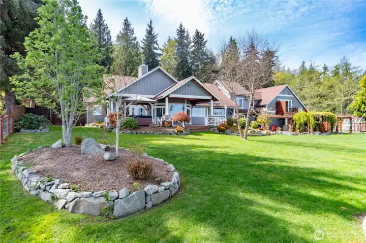 A look at the front beautiful front yard. A spacious covered deck with concrete patio is a perfect viewing place.