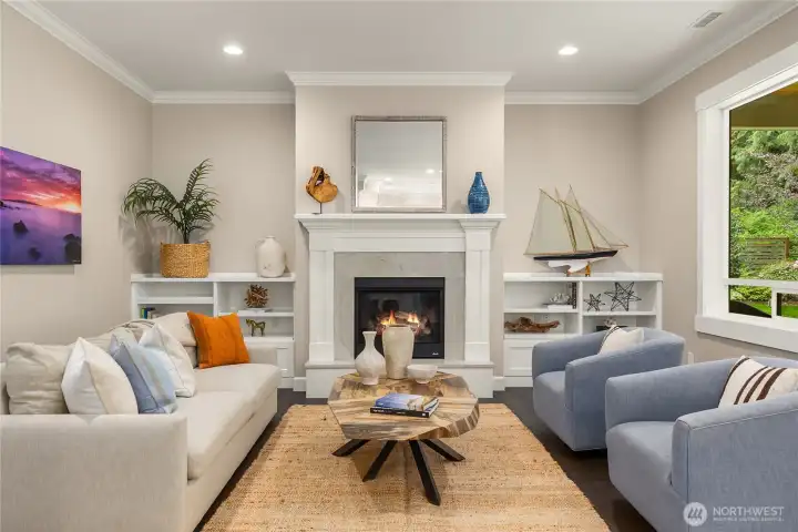 The bright living room has custom built-ins and a propane fireplace