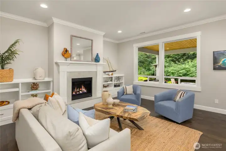 The bright living room has custom built-ins and a propane fireplace