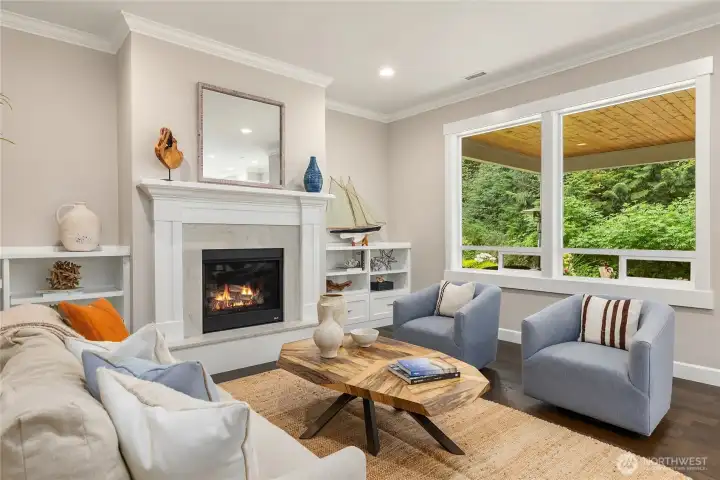 Living room windows look out to the private and spacious porch and trees beyond