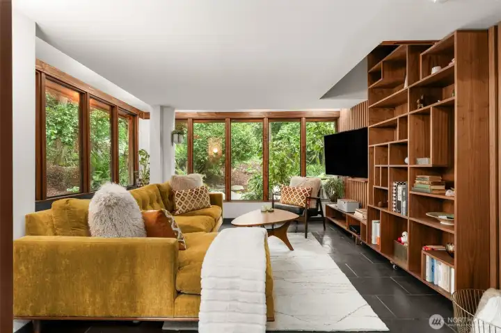 Living room showcases floor to ceiling windows & radiant heated slate floors