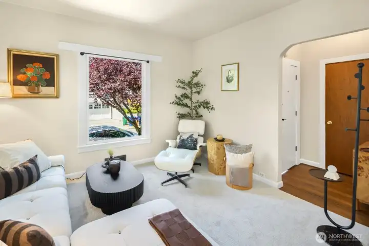 Sunlight pours through oversized windows, creating a warm and welcoming living space with brand-new carpeting (2026) and original fir floors beneath. Such high ceilings throughout this first floor. Sunlight pours through oversized windows, creating a warm and welcoming living space with brand-new carpeting (2026) and original fir floors beneath. Such high ceilings throughout this first floor.