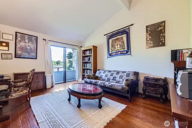 The enormous primary bedroom (currently used as an office) features maple hardwood floors, serene views, vaulted ceilings, and generous closet space.