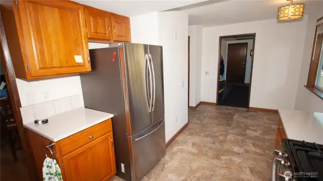This angle shows the depth of the kitchen to the back bonus room which is a mudroom with it's own door access by garage door. There is kitchen table space with a sizable viewing window.