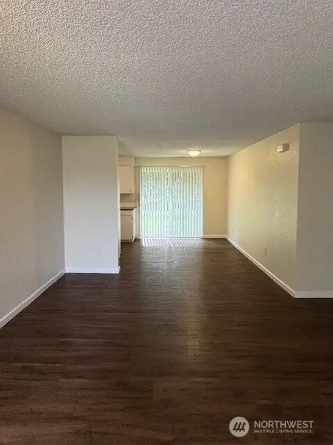 View from living room to dining and slider to backyard.