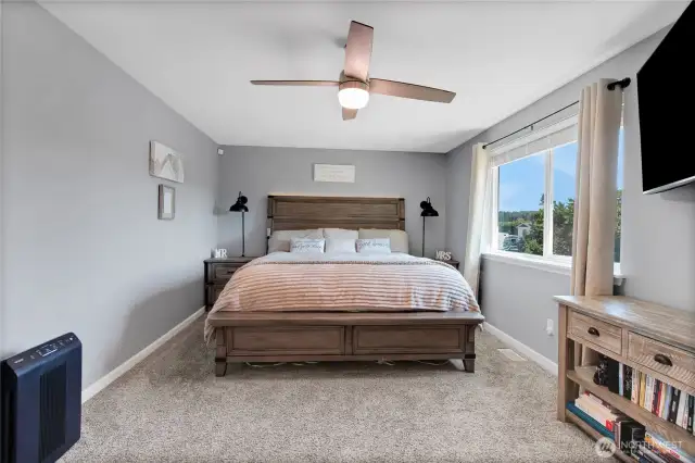 Primary bedroom with new carpet, moulding, ceiling fan, doors and moulding.