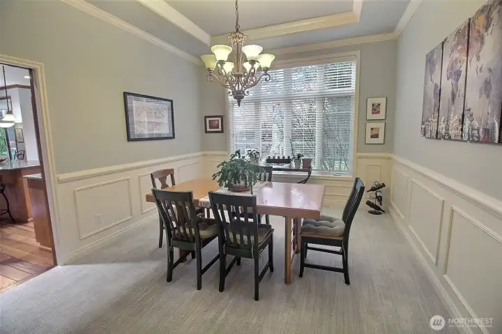 Wainscoting surrounds this Formal Dining Room, trimmed off with crown & cove molding, a beautiful chandelier and steps from the grand kitchen.