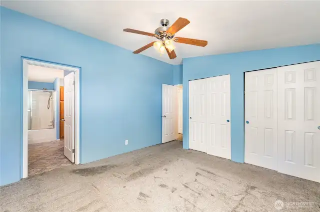 Primary bedroom features ceiling fan, dual closets and en-suite bathroom.