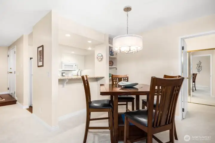 Dining area positioned beside the granite breakfast bar and kitchen pass-through.