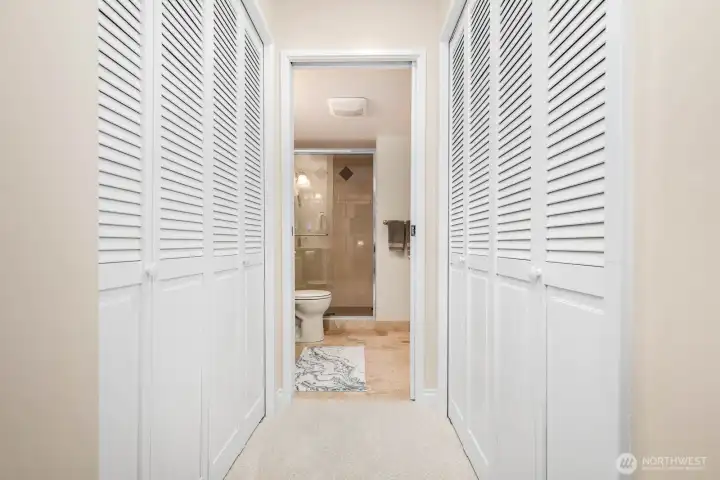 Hallway lined with double louvered closets offers generous storage for the guest suite.