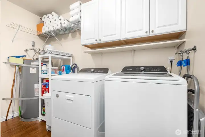 Dedicated laundry room with cabinet storage and utility shelving keeps everything organized. (Note: washer, dryer, and chest freezer do not convey.)