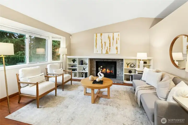 A bright and cozy living room with wood burning fireplace. The seller has a RealFlame firplace log set which accepts 3 Real Flame Fireplacefuel cans. This set can stay with the house.