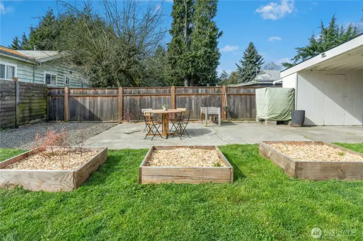 Huge fully fenced backyard with patio area, and garden beds!