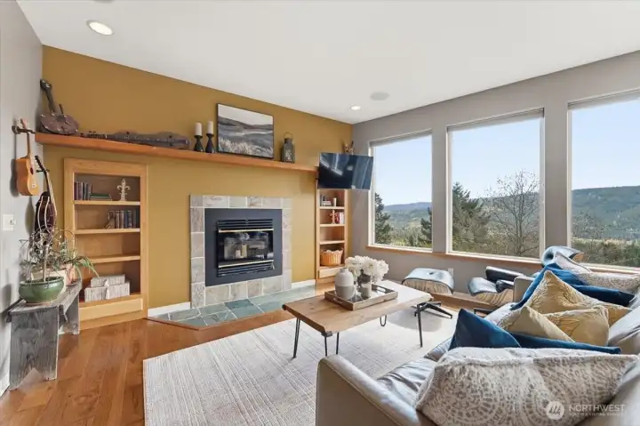 A beautifully appointed main living space framed by sweeping views and anchored by a cozy wood-burning fireplace.