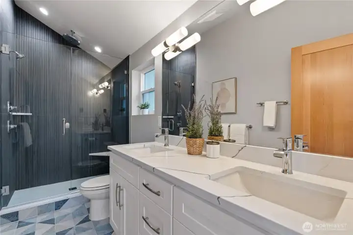 Custom tile bathroom with a vaulted ceiling shower and a double vanity.