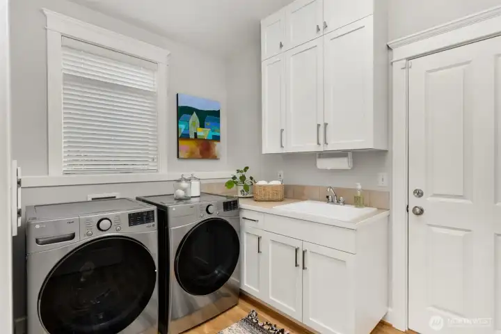 The large laundry area off of the kitchen has a sink, more cabinetry storage and a large pantry.