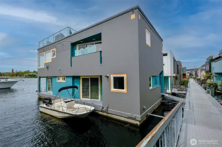The side and water elevation show the home's three levels — entry, main living, rooftop — and the slip that runs its full length.