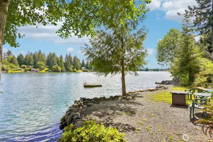 Level open area at waterfront with sitting area and dock