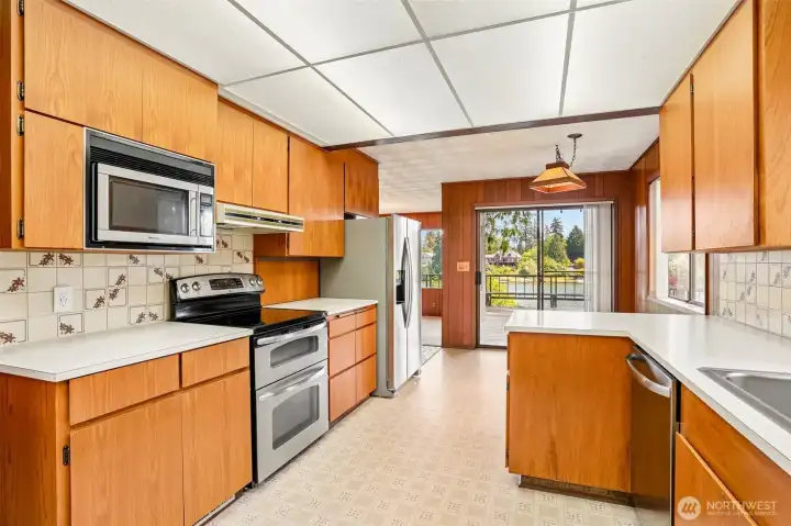 Main kitchen with stainless appliances and eating area.