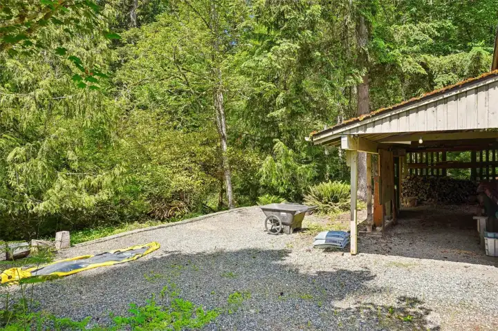 Carport/wood storage/graveled parking.
