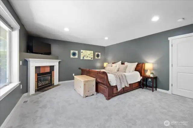 Primary bedroom is very spacious and has a propane fireplace and recessed lighting.