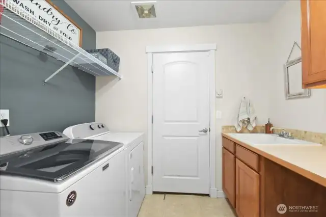 Laundry room with utility sink is just off the garage. Washer and Dryer stay!