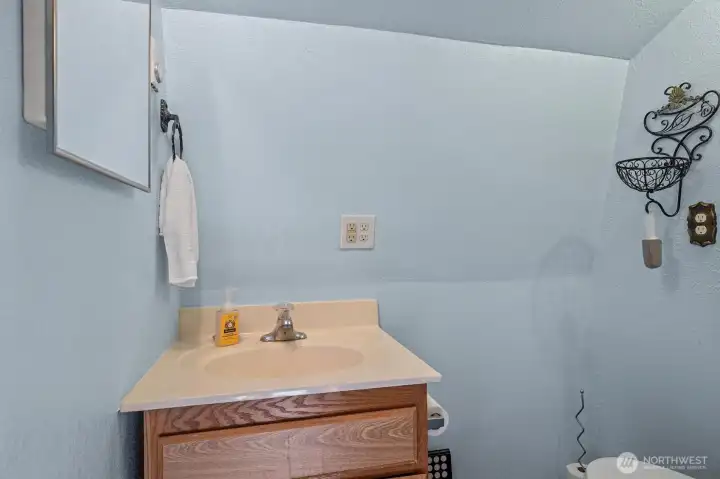 Half bath upstairs with sink and toilet.